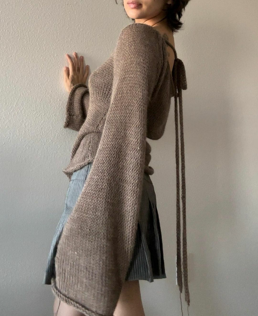 Maglione con manica campana e scollo sulla schiena