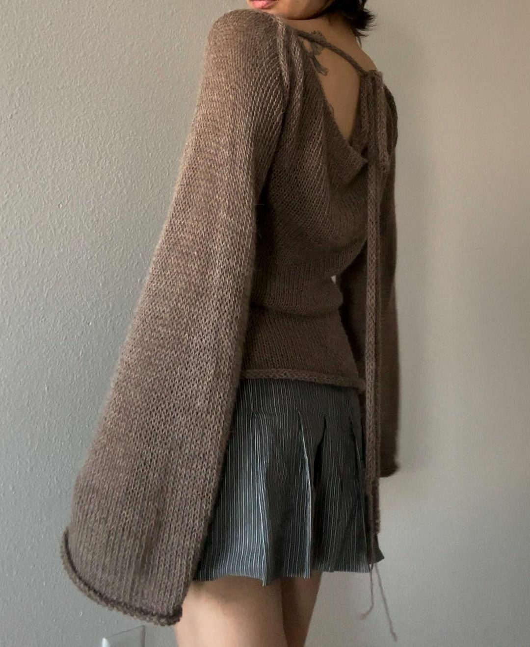 Maglione con manica campana e scollo sulla schiena